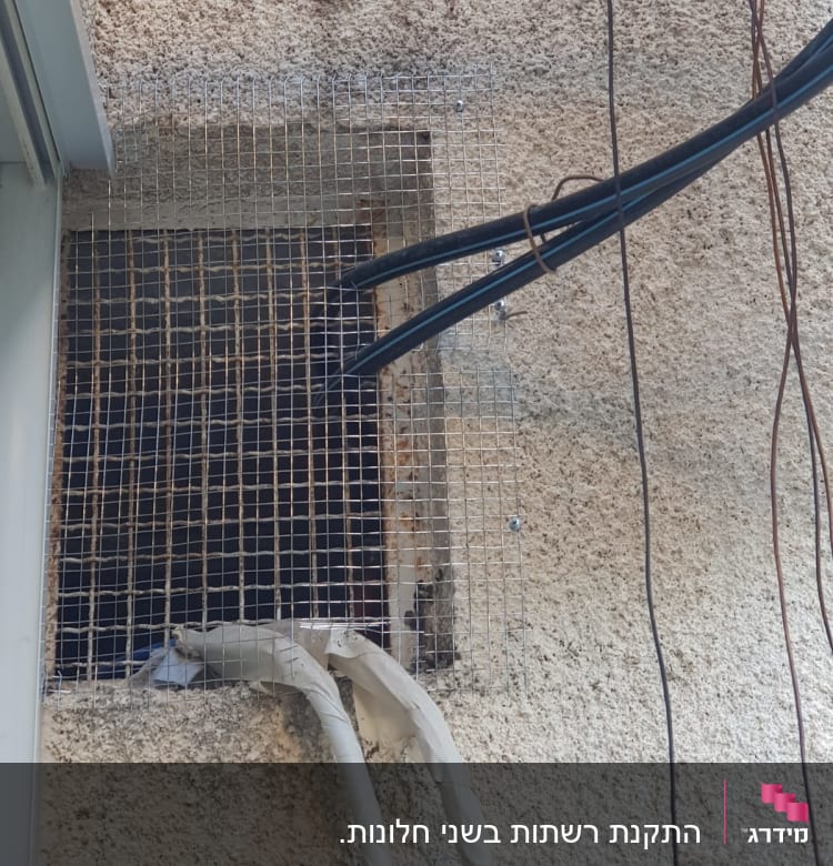 רשת אלומיניום מותקנת על קיר עם כבלים